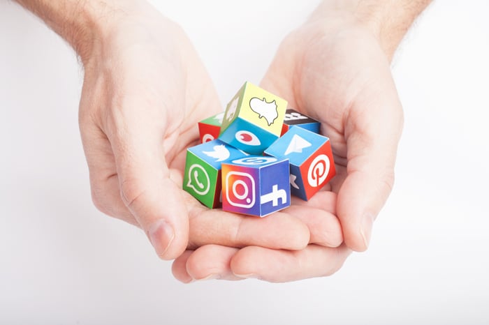 Hands holding colorful cubes with popular social media logos — symbolizing the missed opportunity when private practices ignore social platforms in their digital strategy.