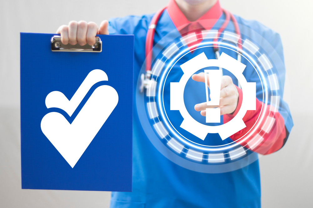 Healthcare professional holding a blue checklist icon and pointing to a virtual gear with an exclamation mark, representing a checklist for HIPAA-compliant medical website development.