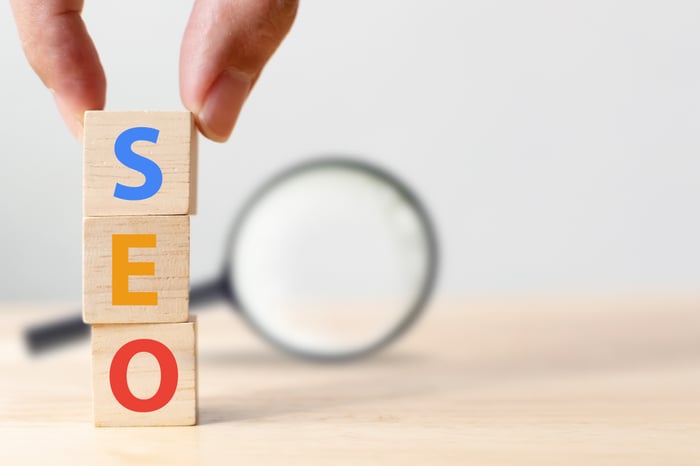 "Stacked wooden blocks spelling SEO with magnifying glass in background—symbolizing long-term visibility and patient growth through healthcare SEO."