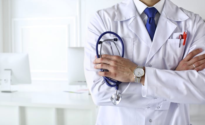 Confident medical professional holding a stethoscope, symbolizing experience and authority in patient care and medical website credibility.