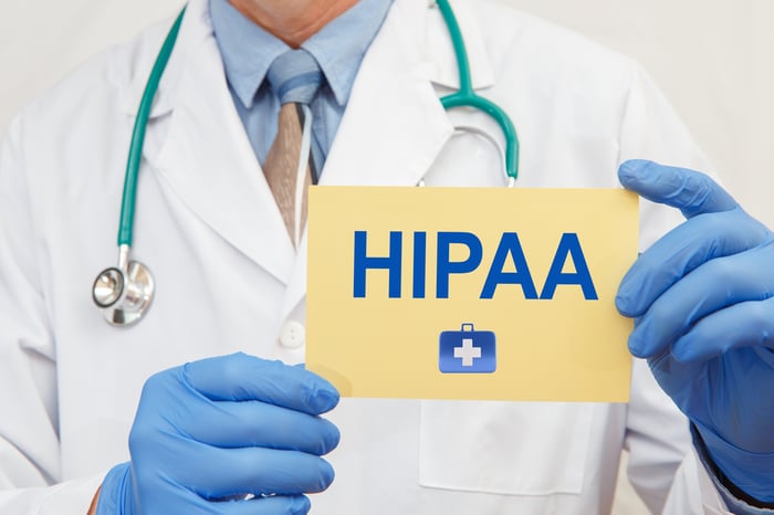 Doctor holding HIPAA sign, emphasizing the importance of HIPAA compliance and patient data protection in healthcare website strategy
