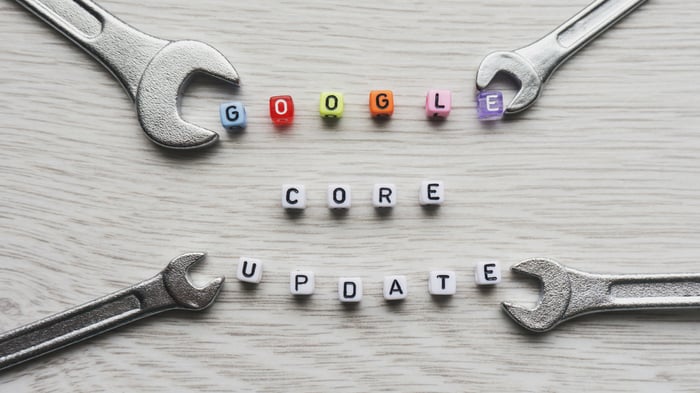 The words GOOGLE, CORE, and UPDATE spelled out with letter beads on a wooden surface, framed by four chrome wrenches, symbolizing the technical maintenance and strategic changes of the 2025 Google Core Updates for SEO.