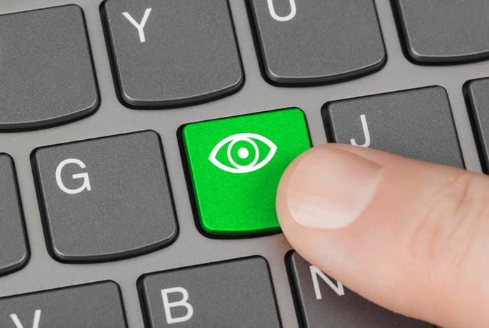 Accessibility concept with a finger pressing a green keyboard key featuring an eye icon, representing vision-friendly website design for seniors in ophthalmology.