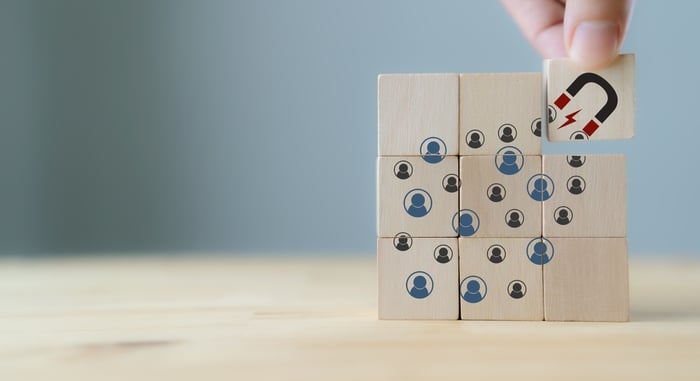 A magnet icon is placed with wooden blocks featuring patient icons, emphasizing the failure of complex forms to attract leads in Medical Website Development.