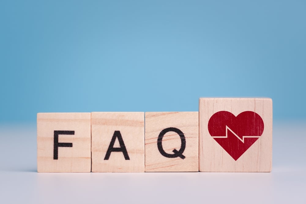 Wooden blocks spelling out 'FAQ' with a fifth block showing a red heart with a white EKG line running through it, representing frequently asked questions about healthcare marketing and SEO strategy for medical practice growth.