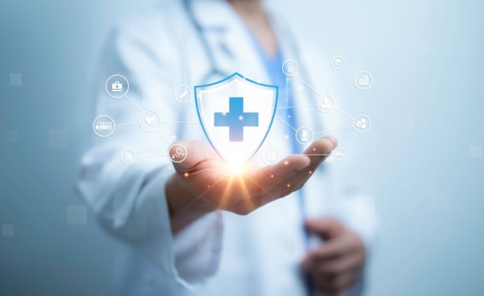 Healthcare professional holding digital medical icons, representing the future of healthcare marketing and digital transformation.