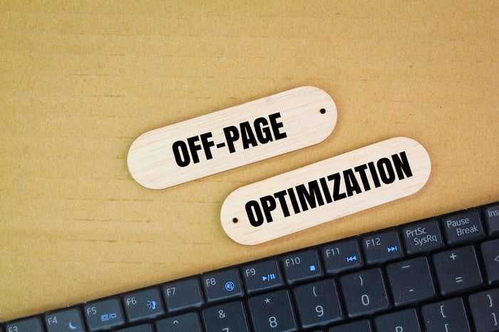 Wooden tags labeled “Off-Page Optimization” placed above a computer keyboard, representing how off-page SEO helps doctors build online authority and trust beyond their medical practice website.