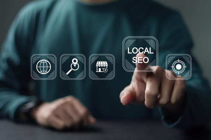 Doctor in green scrubs interacting with digital interface showing “Local SEO” — representing local search optimization for dermatologists and medical practices.