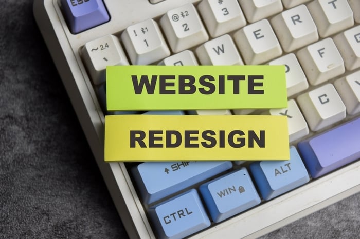 Sticky notes reading “Website Redesign” placed on a colorful keyboard, symbolizing the importance and impact of modernizing healthcare websites for better performance and patient engagement.