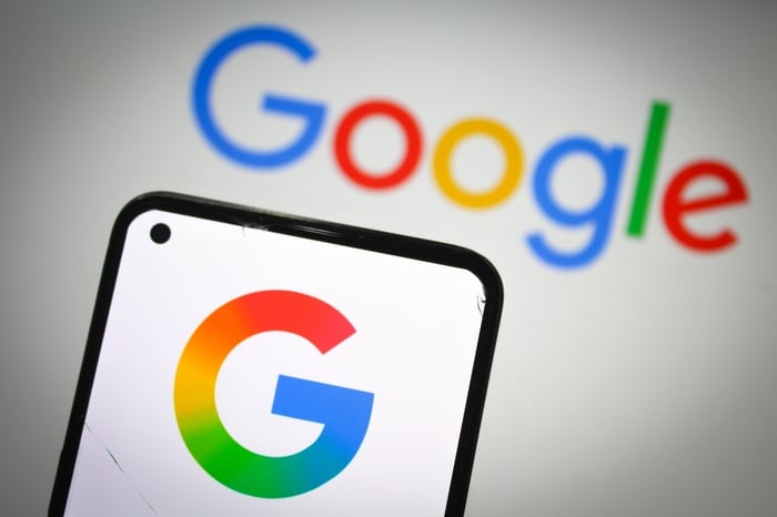 Close-up photo of a smartphone displaying the multicolored Google 'G' logo, with the blurred word "Google" visible in the background. 2025 Google Updates and Digital Marketing for Doctors are the topic of the accompanying article.