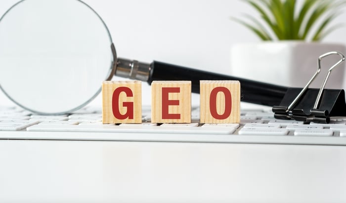 Wooden blocks spelling 'GEO' on a keyboard with a magnifying glass, illustrating how SEO for doctors is evolving into Generative Engine Optimization in 2026.